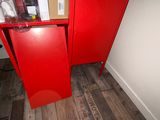 a red cabinet in the corner of a room