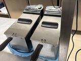 deux friteuses posées sur un plan de travail dans une cuisine