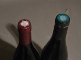 two bottles of wine sitting next to each other on a table
