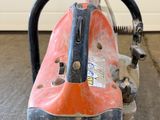 an orange and black machine sitting on top of a cement floor