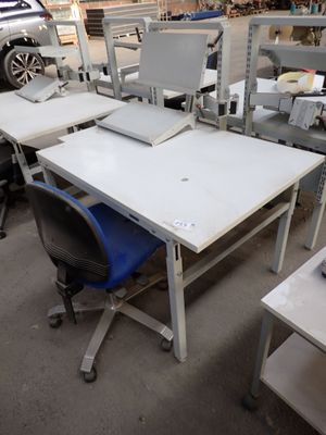 a table with a laptop on it and a chair in front of it