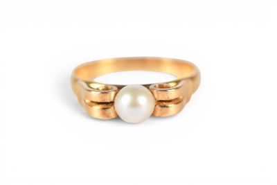 a close up of a gold ring with a pearl in it
