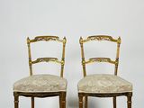pair of gilded chairs with upholstered seats in the style of louis ii