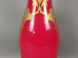 un vase rouge orné d'un motif doré