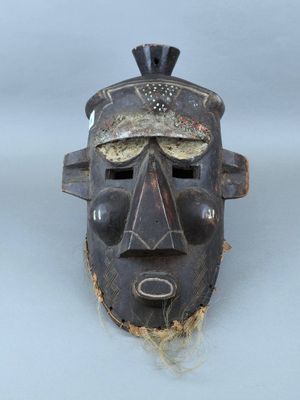 une image représentant un masque en bois sur un fond blanc