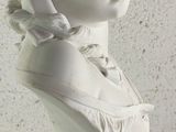 a white bust of a woman on a blue pedestal
