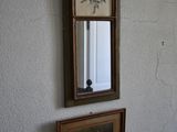 two framed pictures hanging on the wall next to a mirror