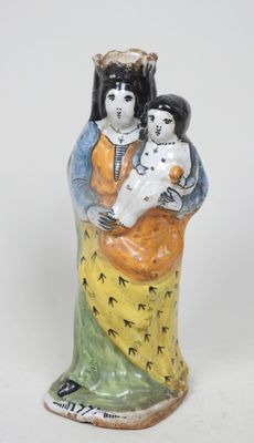 une figurine représentant une femme tenant un enfant et un chien dans ses bras