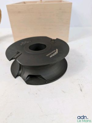 une bobine noire posée sur une table, à côté d'une boîte en bois