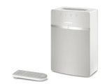 La chaîne hi-fi est blanche et dispose d'une télécommande sur le côté.