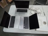 trois ordinateurs portables posés sur une table
