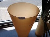 un vase posé sur une table près d'une fenêtre