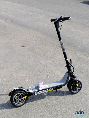 un scooter posé par terre sur le parking