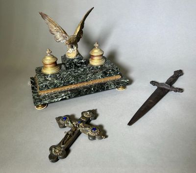 une petite statue représentant un aigle et une croix, à côté d'un couteau