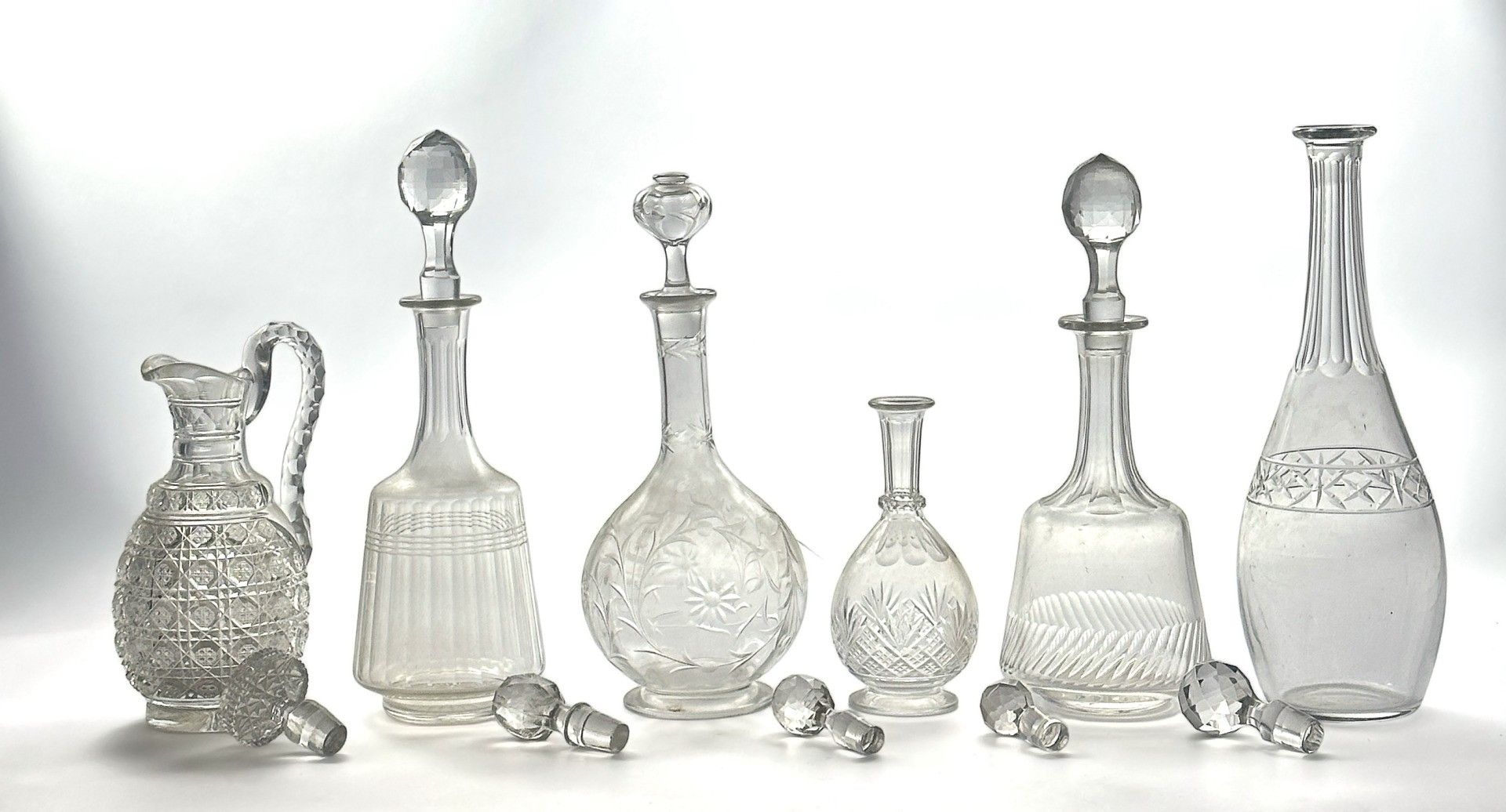 LOT de 6 carafes et 1 pichet en verre et cristal, certaines à décor taillé à la roue et 1 ensemble de 8 bouchons en v...