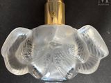 an image of a clear glass perfume bottle with a gold top