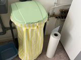 une poubelle à côté des toilettes dans une salle de bains