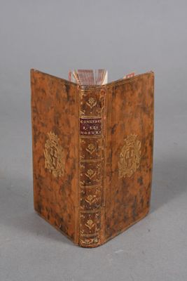 an old book sitting on top of a table next to a white wall