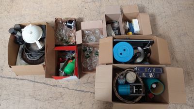 plusieurs cartons contenant des objets divers, posés par terre dans une pièce