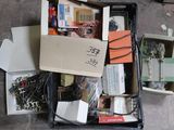 une boîte remplie de composants électroniques divers, posée par terre