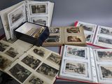 beaucoup de vieilles photos posées sur une table, à côté d'une lampe