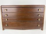 a wooden chest of drawers with brass knobs on each drawer