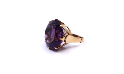 a close up of a ring with a purple stone on a white background