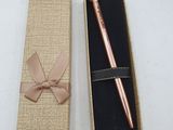 a pink pen in a box with a bow on it