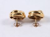 a pair of gold earrings with a knot on each ear