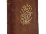 un vieux livre marron avec un motif doré sur la couverture