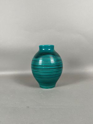 a green vase that is sitting on a white surface