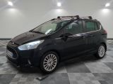 La voiture noire est garée sur le sol à damier du garage.