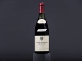 a bottle of wine sitting on top of a table next to a glass