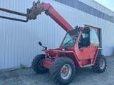 a red tractor that is parked in front of a building