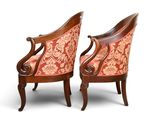 pair of antique chairs with upholstered armrests and ornate upholstered backrests