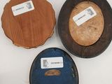 three wooden picture frames with labels on them sitting on a white surface