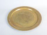 a gold plate with a design on it on a white surface
