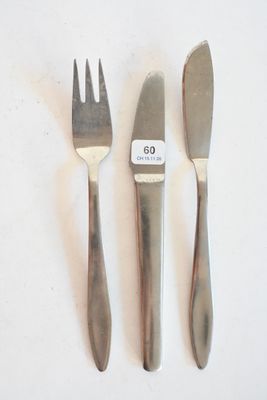 trois fourchettes et un couteau sur une table blanche