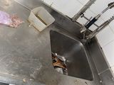 a dirty sink in a dirty kitchen with a dirty floor