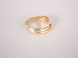 a close up of two gold rings on a white surface
