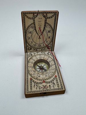 une boîte contenant une boussole, posée sur une surface blanche