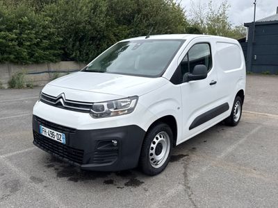 une camionnette Citroën garée sur un parking devant un immeuble