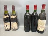 four bottles of wine are lined up on a table
