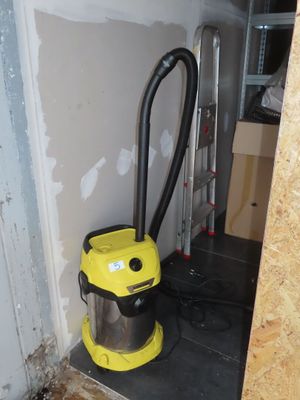 a yellow and black vacuum in the corner of a room