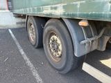 a green truck with a flat tire parked in a parking lot