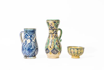 trois petits vases posés les uns à côté des autres sur une surface blanche