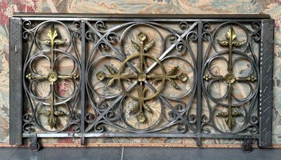une grille décorative en fer ornée de croix et de fleurs