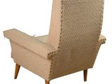 an upholstered chair with a buttoned back and legs