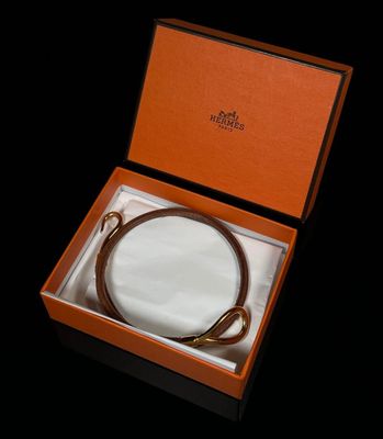 une boîte orange contenant une ceinture en cuir marron