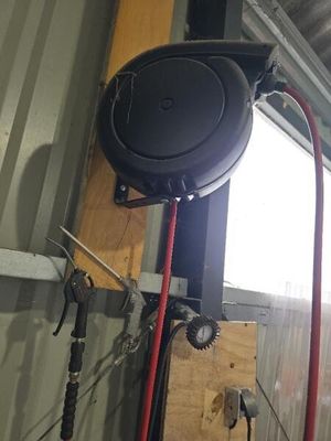 une photo d'un garage avec un tuyau d'arrosage et un souffleur